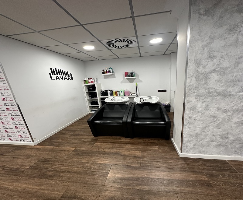 Zona de lavado del salón con dos sillones negros